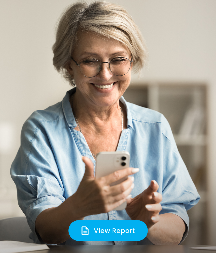 Smiling senior woman looking at her phone, illustrating worry-free personalized virtual dental care.