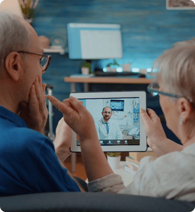 Senior couple having a virtual dental consultation with a Medicaid dentist on a tablet using Dentistry.One.