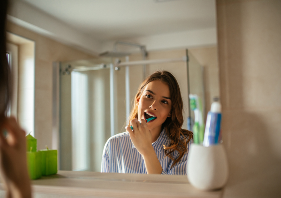 Woman in mirror looking at mouth for gum disease