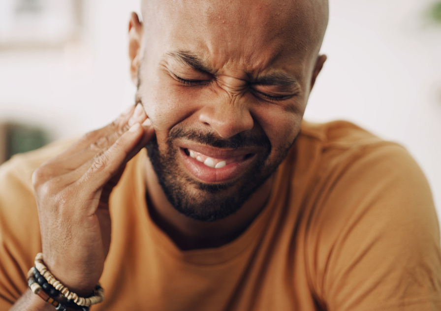 Man holding mouth in pain due to dental emergency