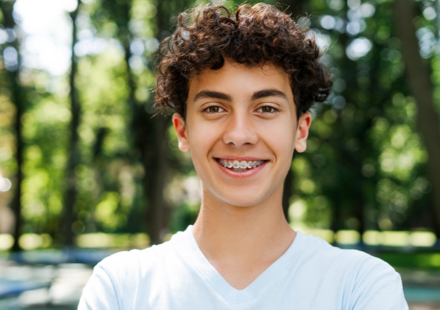 Teenager with braces standing outside