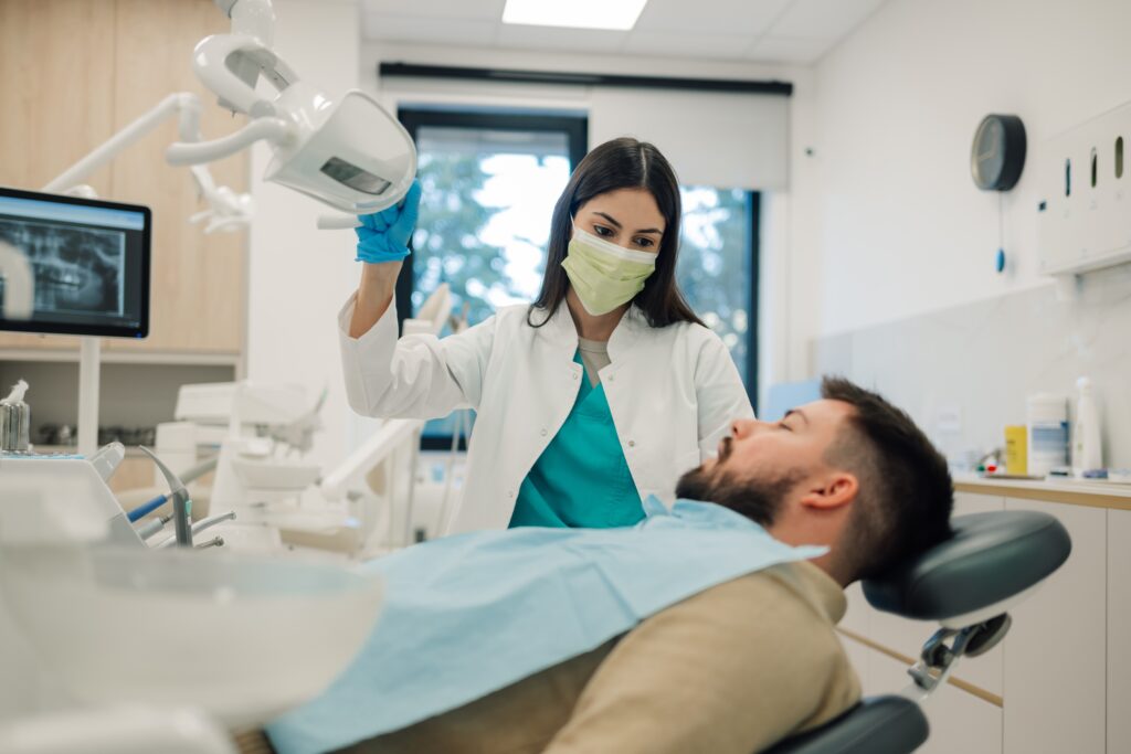 Patient in a dentist chair looking at dentist