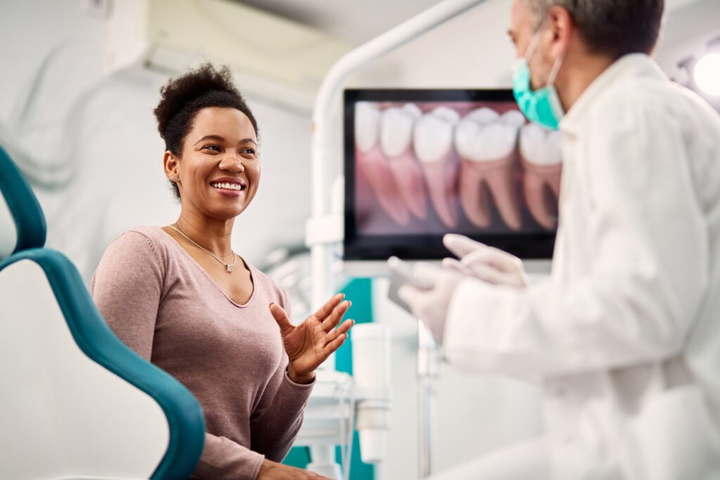 Woman in a dentist chair talking to a dentist