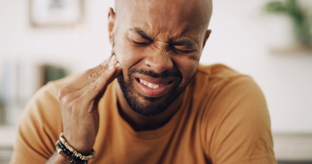 Man touching side of face because of tooth pain