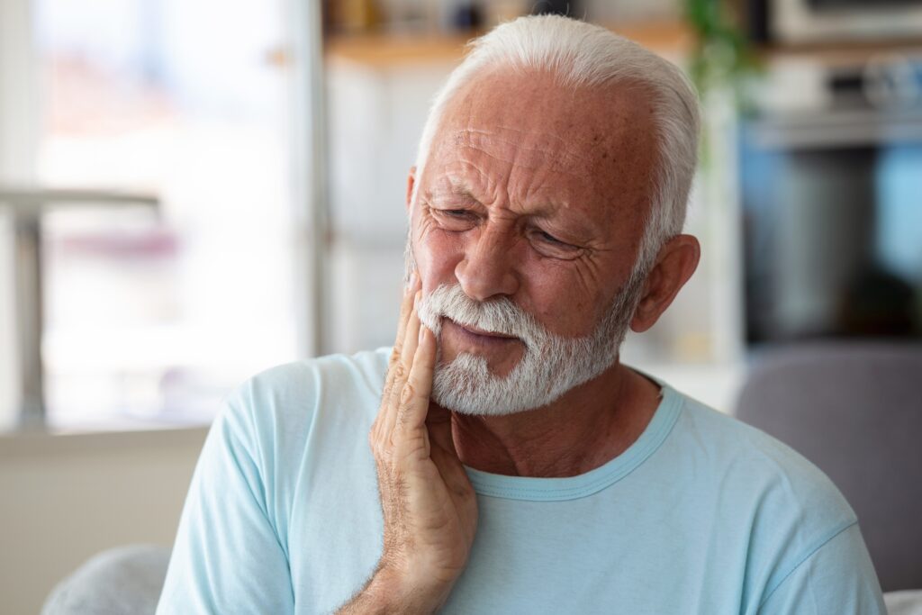 Man holding mouth in pain