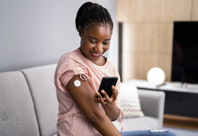 Woman taking glucose levels using her phone